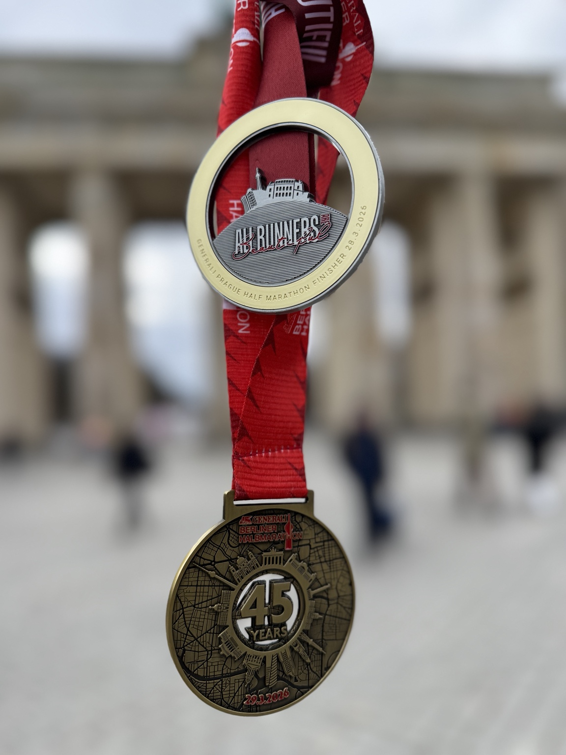 Die Finisher-Medaillen der Halbmarathons in Prag und Berlin 2026
